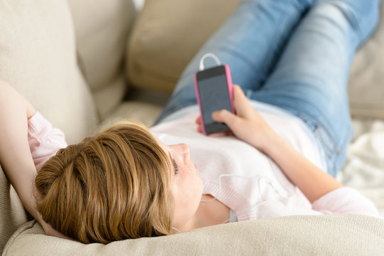 Teenage woman relax on sofa listen music
