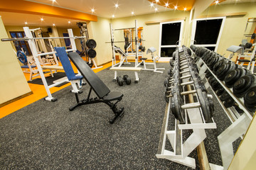 Fototapeta na wymiar Interior view of a gym with equipment and weights.