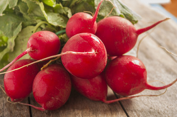 Bunch of fresh radishes on old wooden table