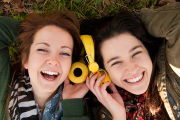 Happy teen girls sharing music