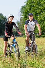 Young Couple With Bicycle In Meadow