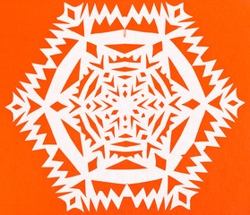 white snowflake on orange paper