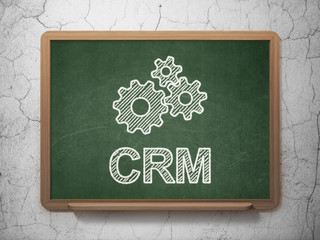 Business concept: Gears and CRM on chalkboard background