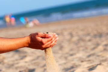 SENTIR LA ARENA DE LA PLAYA CON LAS MANOS.