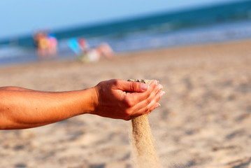 SENTIR LA ARENA DE LA PLAYA CON LAS MANOS.