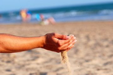 SENTIR LA ARENA DE LA PLAYA CON LAS MANOS.