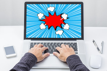 Man hand on laptop keyboard with comic boom screen monitor © littlestocker