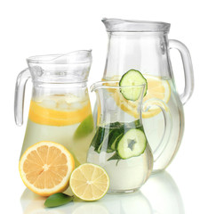 Cold water with lemon, cucumber and ice in pitchers isolated