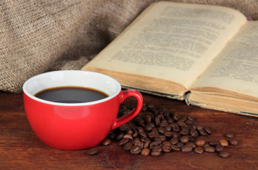 Cup of coffee with coffee beans and book