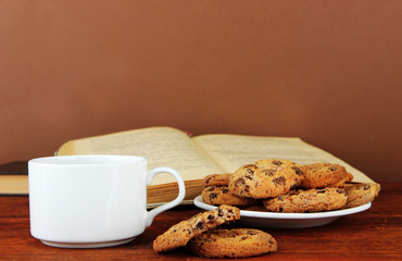 Cup of coffee with cookies and books