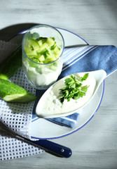 Cucumber yogurt in glass, on color napkin, on wooden