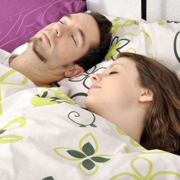 Paar schl&auml;ft im Bett