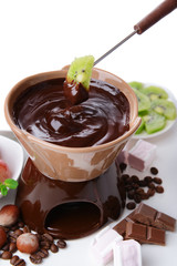 Chocolate fondue with marshmallow candies and fruits, isolated