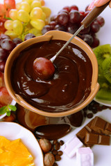 Chocolate fondue with marshmallow candies and fruits, isolated