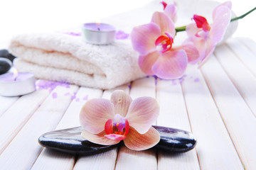 Fototapeta na wymiar Still life with beautiful blooming orchid flower, towel and spa
