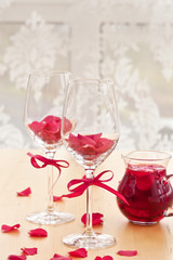 Zwei Glaeser mit Rosenblueten