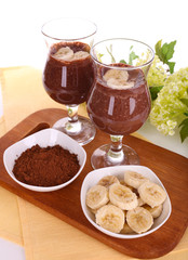 Cocktails with banana and chocolate on table on white