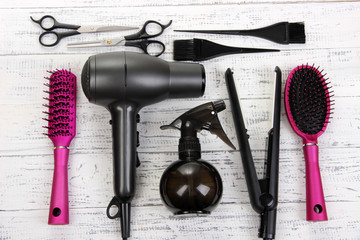 Hairdressing tools on white wooden table close-up