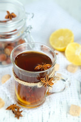 Hot beverage in glass cup with fruits and spices,