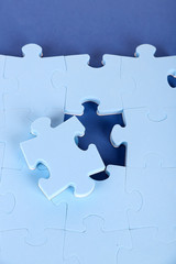 Last piece of jigsaw puzzle, close-up, on blue background