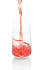 Juice pouring into glass isolated on white