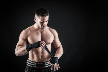 Fototapeta na wymiar Sportsman kick boxer intense portrait against black background.