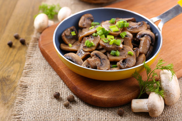 Delicious fried mushrooms in pan on table close-up