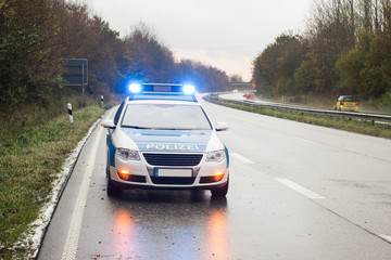 Polizeiauto / Streifenwagen mit Blaulicht auf der Autobahn