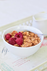 Healthy breakfast: cornflakes with milk and raspberries