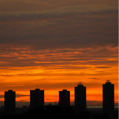 Obraz na płótnie Canvas Sun rising over some of high building