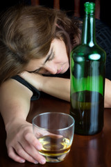 Drunk woman sleeping and holding a glass of whisky