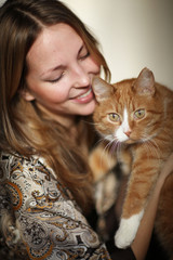 portrait of a beautiful girl with a red cat