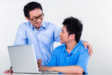 Asian father and son learning at home for school