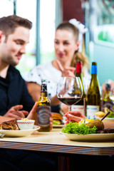 Friends eating and drinking in fast food diner