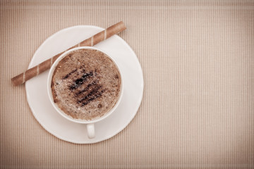 White cup coffe and waffle roll with cream on brown background