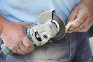 construction worker using an angle grinder cutting tile