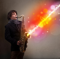 Obraz na płótnie Canvas Young man playing on saxophone with colorful sound waves