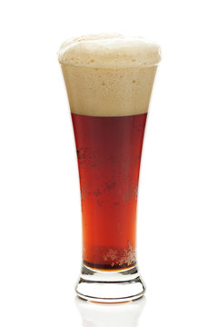 dark beer with the foam in a tall glass isolated on white