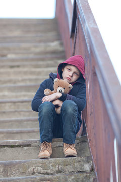 homeless boy sitting on the bridge