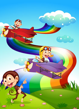 A sky with a rainbow and planes with monkeys