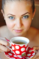 Beautiful woman holds the cup of cowberry tea