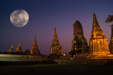 historic buddha temple with full moon in Thailand