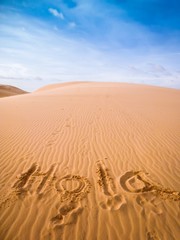 "Hola" written in desert sand © Nektarstock