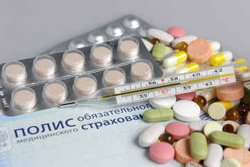Таблетки с градусником и медицинском полисом