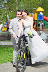 Happy newly married couple with a bicycle