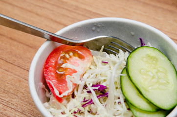 Tomato, cucumber and cabbage salad in a white bowl