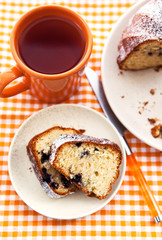 Piece of homemade bundt cake on plate with orange mug