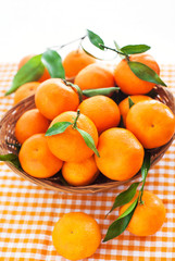 Fresh tangerines with leaves in a  basket