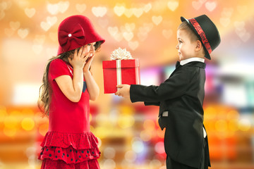 Little boy giving girl gift and his excited