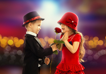 Lovely little boy giving  a rose to girl